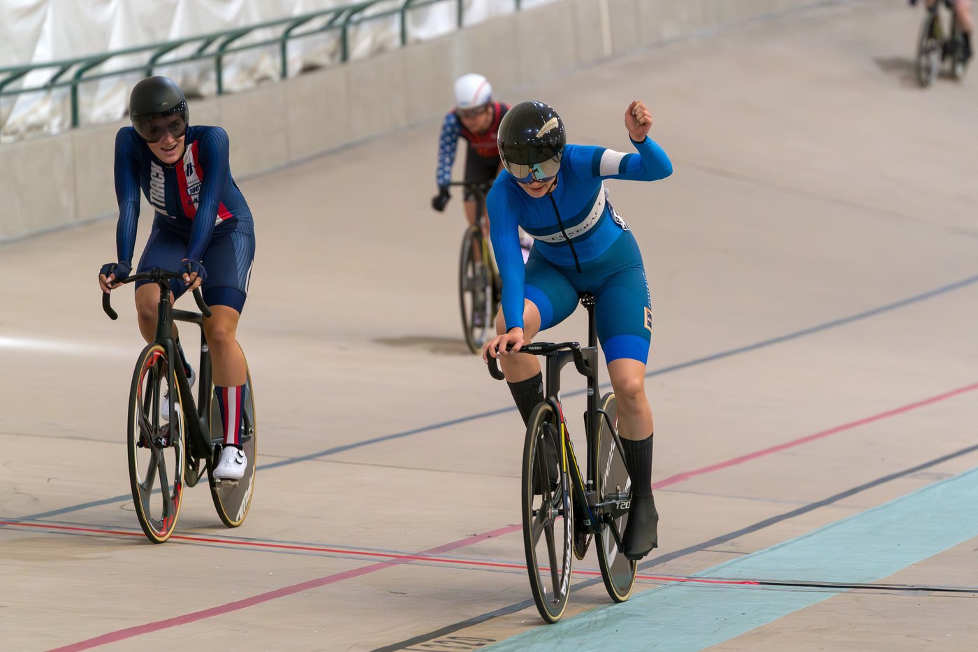 M celebrates her win in the USAC Elite Keirin championships 2025, with an upraised arm, rolling over the finish line