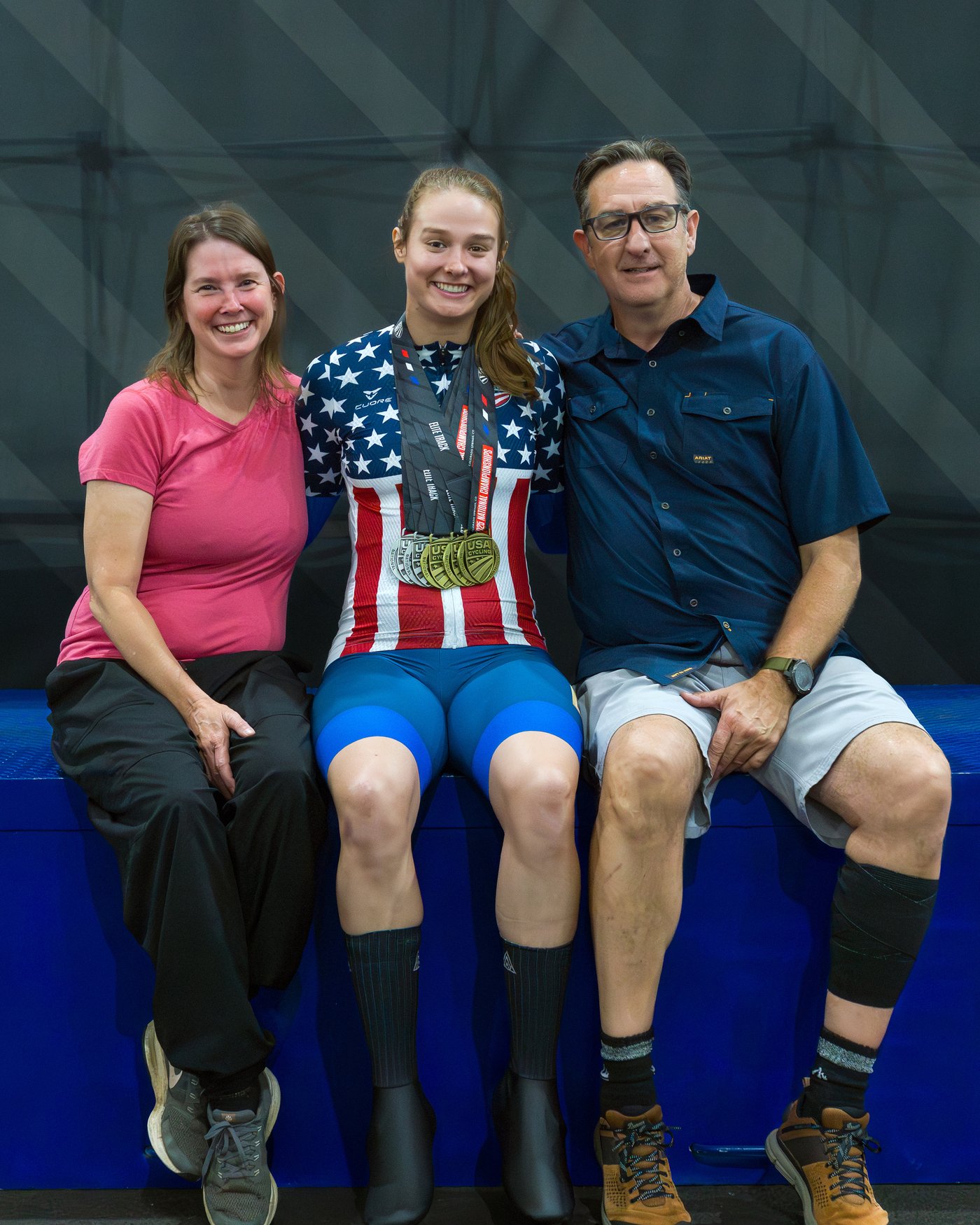 M, with champion jersey and medals, and her parents